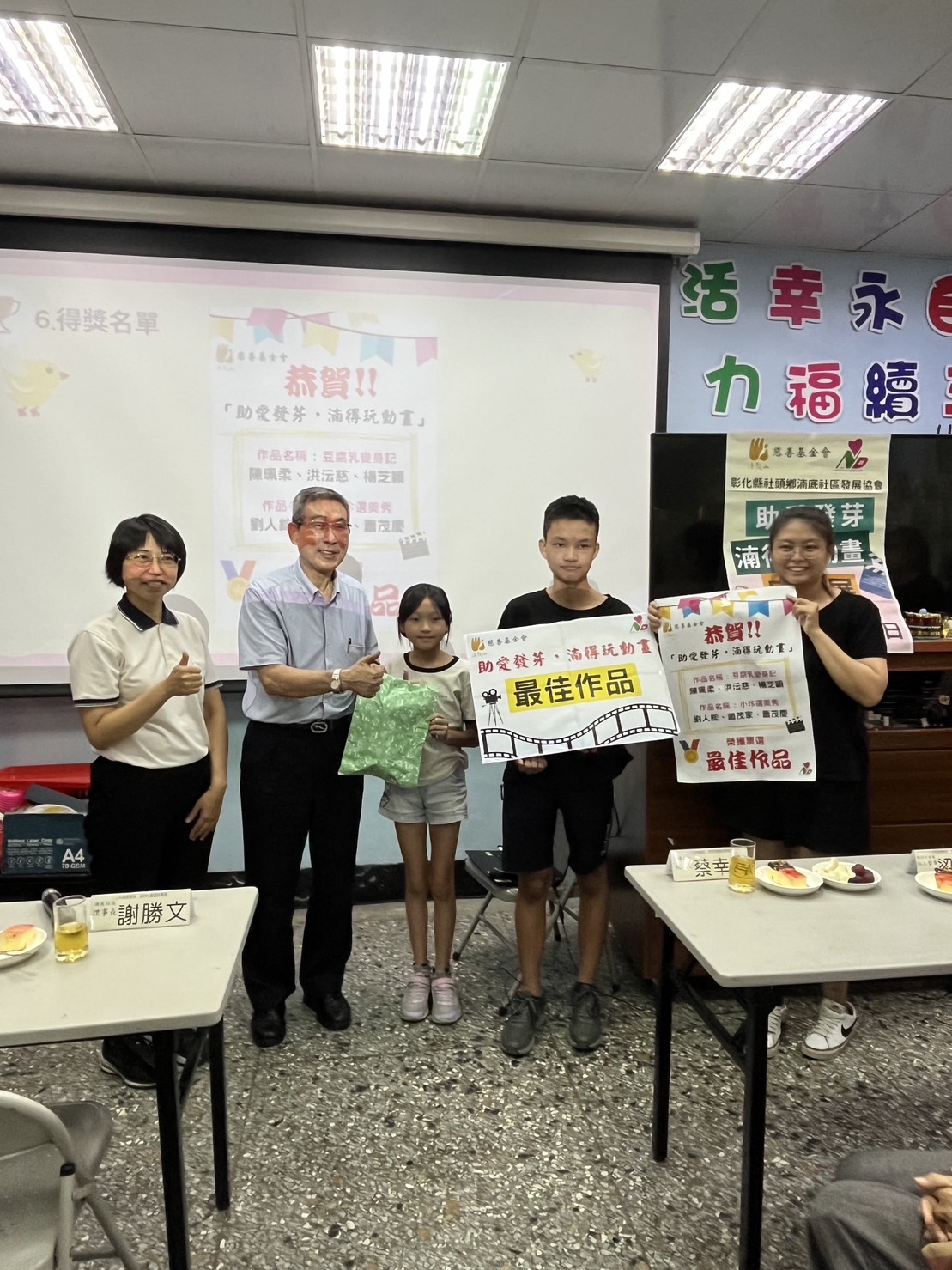 法鼓山慈基會董事陳治明代表致贈獎品給參與創作最佳作品的學童。